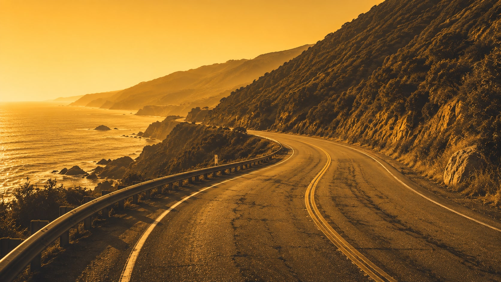 A coastal road curving toward the sunset, golden-hour light